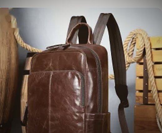 A brown leather rucksack hung against a wall